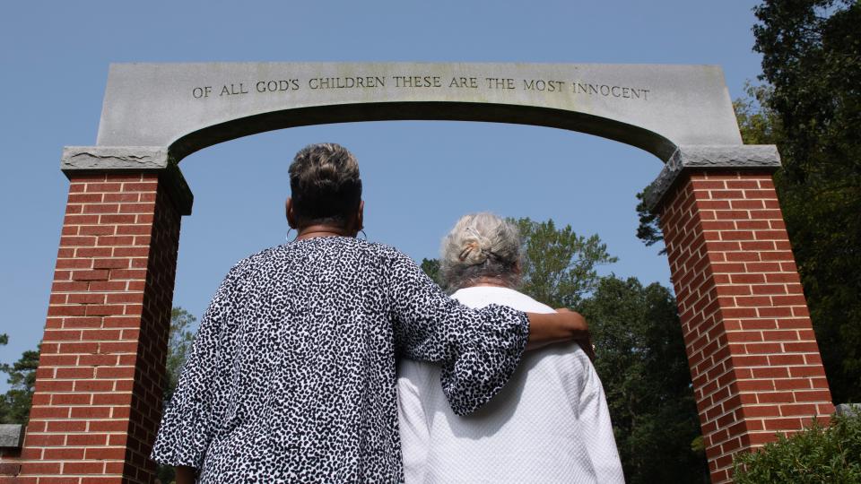 Relatives of Ethel Benson stand near the entrance of Stockley Center Cemetery in Georgetown, Delaware, as they visit Benson's headstone. Benson was sterilized in 1932 and died weeks later.