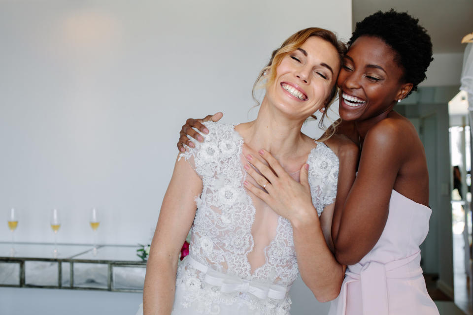 A bride and bridesmaid hugging