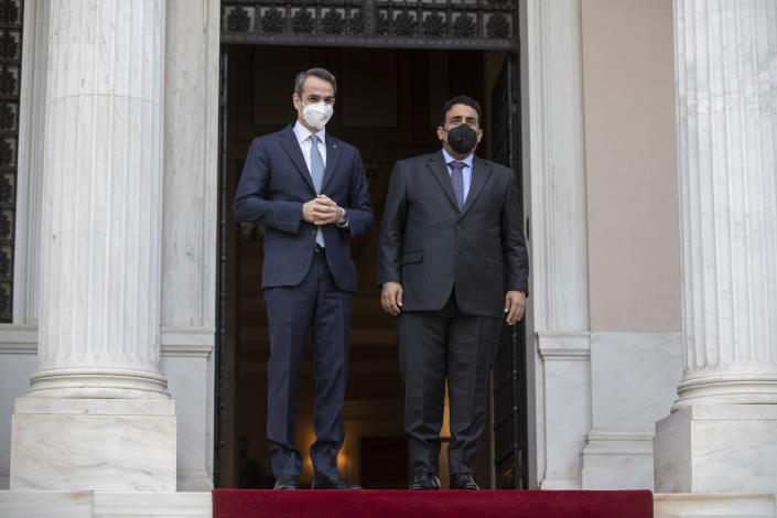 Greek Prime Minister Kyriakos Mitsotakis, left, and the head of the Presidential Council of Libya Mohamed al-Menfi, wear face masks to curb the spread of COVID-19 as they pose for photographers before their meeting, in Athens, on Wednesday, April 14, 2021.(AP Photo/Petros Giannakouris)