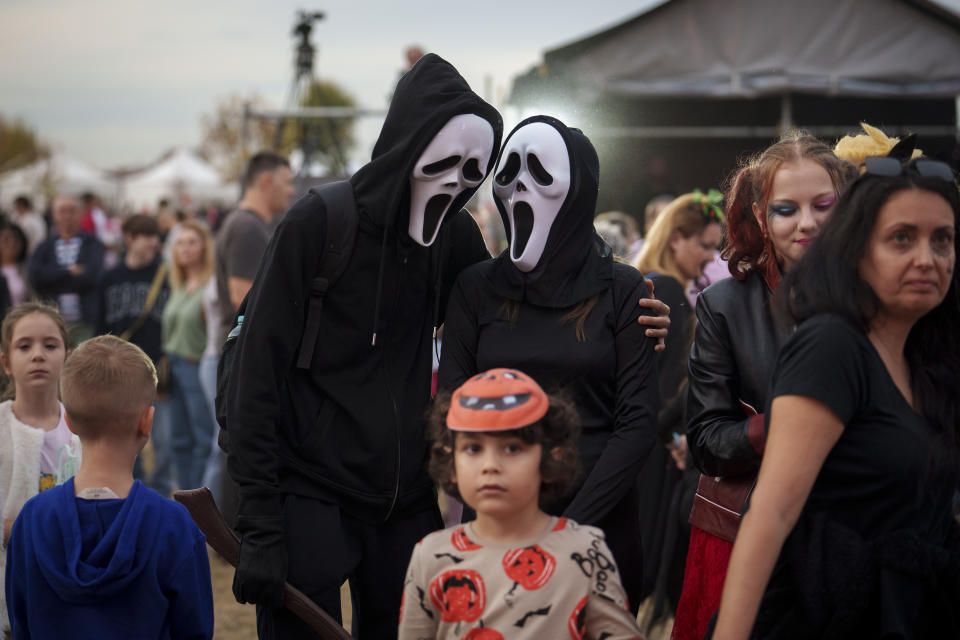 People wearing costumes talk at the West Side Hallo Fest, a Halloween festival in Bucharest, Romania, Friday, Oct. 27, 2023. Tens of thousands streamed last weekend to Bucharest's Angels' Island peninsula for what was the biggest Halloween festival in the Eastern European nation since the fall of Communism. (AP Photo/Vadim Ghirda)