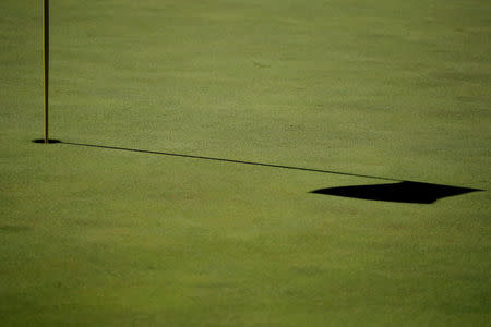 The pin on the 6th hole casts a shadow across the green during a practice round for the 2017 Masters at Augusta National Golf Club in Augusta, Georgia, U.S. April 4, 2017. REUTERS/Jonathan Ernst