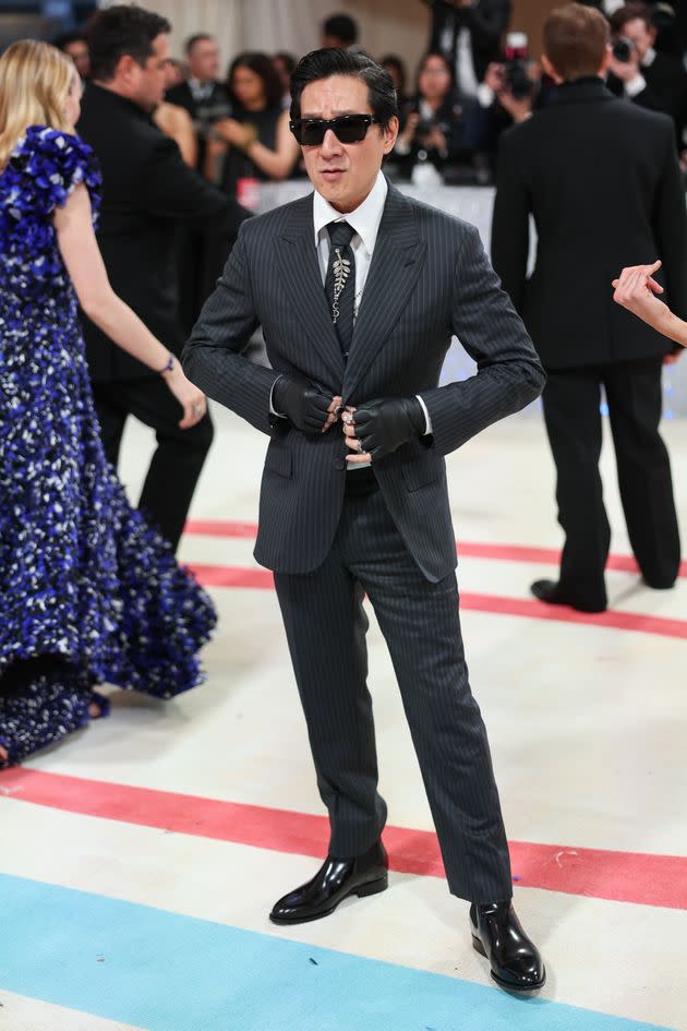 Ke Huy Quan pairs a dapper suit with fingerless gloves at the Met Gala. 