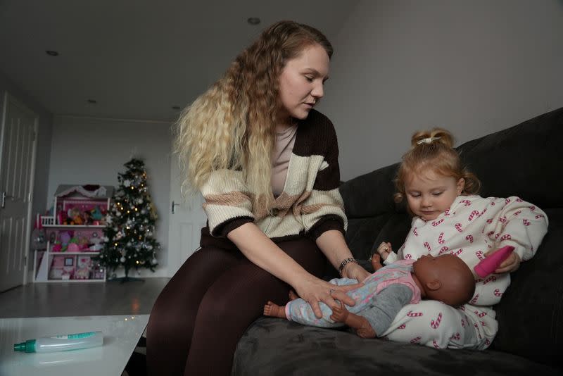 Paige Ballmi poses with her daughter Fifi at their home during an interview with Reuters, in London