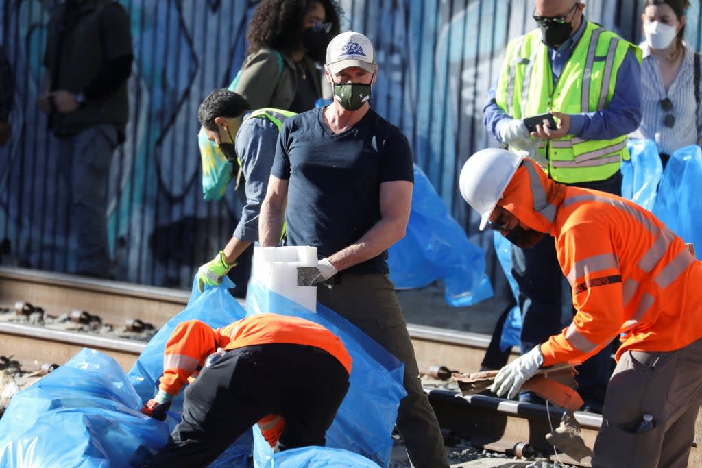 California Governor Gavin Newsom visits and helps clean the site where multiple train looting has occurred along the freight train tracks in Los Angeles, California U.S., January 20, 2022 (REUTERS)