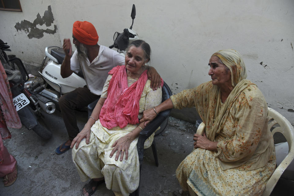 Relatives of victims mourn near the site of an explosion at a fireworks factory in Batala, in the northern Indian state of Punjab, Wednesday, Sept. 4, 2019. More than a dozen people were killed in the explosion that caused the building to catch fire and collapse, officials said. (AP Photo/Prabhjot Gill)