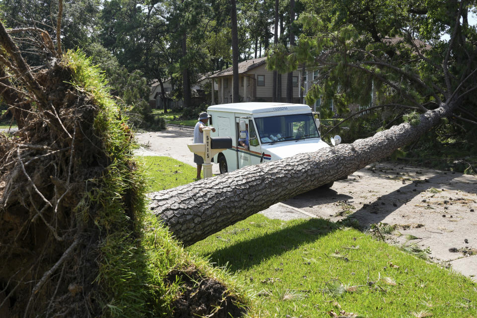 Delray Gooch, standing, talks to mail carrier Jason Phillips as he delivers mail in the aftermath of Hurricane Beryl on Wednesday, July 10, 2024, in Houston. (Jon Shapley/Houston Chronicle via AP)