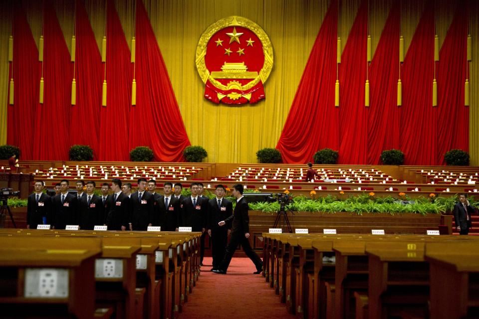 Chinese security personnel form up after a session of the National People's Congress held at the Great Hall of the People in Beijing, China, Sunday, March 9, 2014. China will tighten environmental legislation and force polluters to pay compensation following renewed blasts of toxic air, the country's top legislator said Sunday. (AP Photo/Ng Han Guan)
