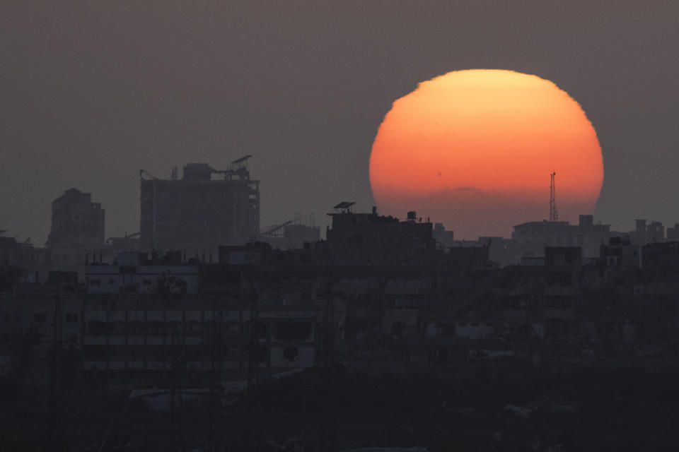 The sun sets behind the buildings in the Gaza Strip as seen from southern Israel, Saturday, June 29, 2024. (AP Photo/Leo Correa)