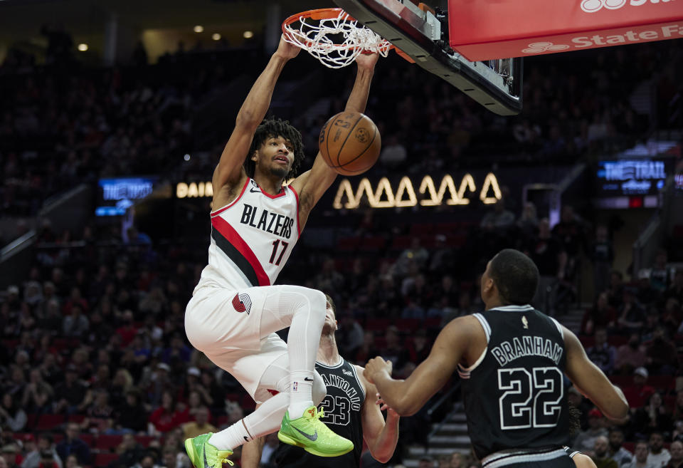 Portland Trail Blazers guard Shaedon Sharpe, left, dunks over San Antonio Spurs guard Malaki Branham during the second half of an NBA basketball game in Portland, Ore., Monday, Jan. 23, 2023. (AP Photo/Craig Mitchelldyer)