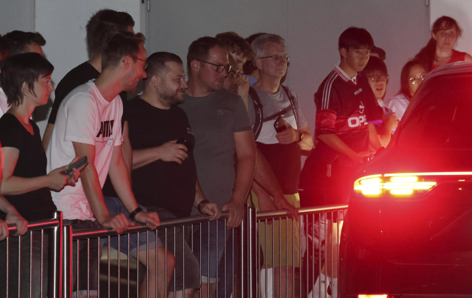 FC Bayern Munich fans wait at the club's Säbener Strasse ground for the arrival of England captain Harry Kane in Munich, Germany, Friday, Aug. 11, 2023. Kane's transfer from Tottenham to Bayern Munich is “imminent,” Spurs manager Ange Postecoglou said Friday, in a deal that will reportedly be worth more than 100 million pounds ($110 million). Kane arrived at a Munich hospital on Friday evening for medical tests as fans gathered outside the club’s headquarters. (Mladen Lackovic/dpa via AP)