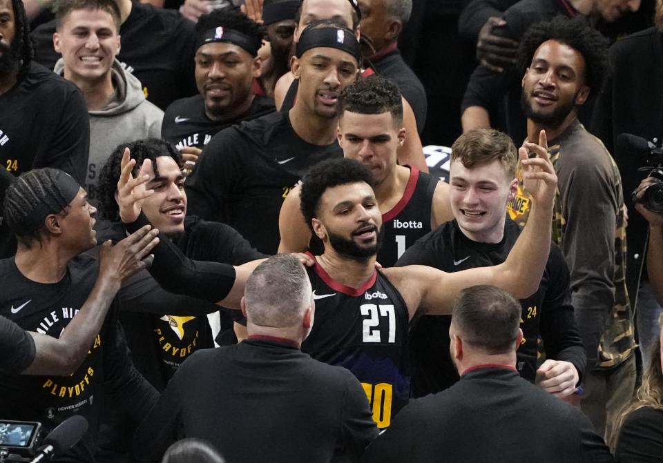Denver Nuggets guard Jamal Murray (27) is congratulated by teammates after hitting the game-winning basket at the buzzer against the Los Angeles Lakers during the second half in Game 2 of an NBA basketball first-round playoff series Monday, April 22, 2024, in Denver. (AP Photo/Jack Dempsey)