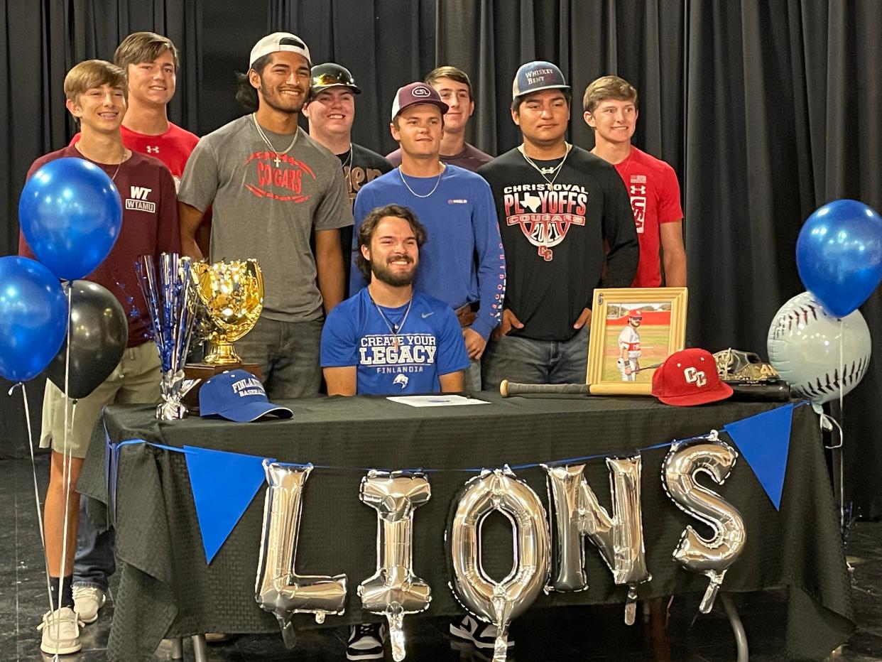 Christoval High School's Cobi Woodfin, seated, poses for a photo with his baseball teammates during a reception Wednesday, May 25, 2022, in Christoval, after Woodfin signed to continue his playing career for Finlandia University in Hancock, Michigan.