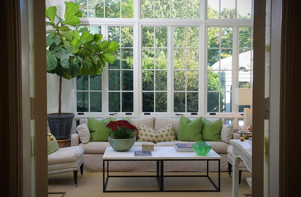 The Solarium in the vice president's official residence. A white sectional decorated with green pillows set under large windows.