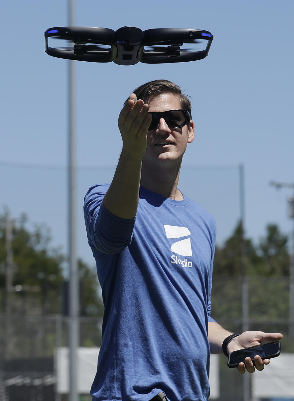In this June 22, 2018, photo, Skydio head of marketing Patrick Stahl demonstrates using an R1 flying camera drone in Redwood City, Calif. Skateboarders, surfers and YouTube stars used to be the target customers for California drone startup Skydio, which builds sophisticated self-flying machines that can follow people around and capture their best moves on video. Now it's police officers and soldiers getting equipped with the pricey drones. U.S. political and security concerns about the world's dominant consumer drone-maker, China-based DJI, have opened the door for Skydio and other companies to pitch their drones for government and business customers. (AP Photo/Jeff Chiu)