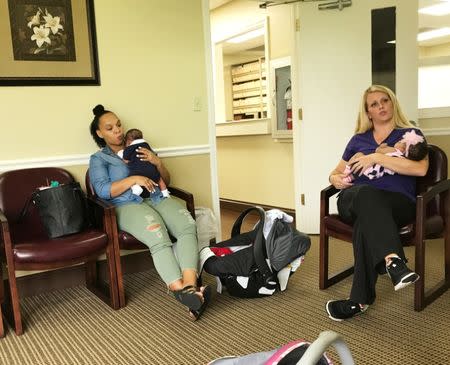 Erica Sanders (L), holds her son Thomas P. Sanders and medical assistant McKenzie Coleman holds Karlee J. Scott as they participate in a group session to learn from the medical staff and each other about everything from nutrition to postpartum depression in Bay Minette, Alabama, U.S. on June 22, 2017. REUTERS/Jilian Mincer