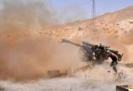 A Syrian army soldier fires artillery shells towards Islamic State group jihadists in northeastern Palmyra on May 17, 2015