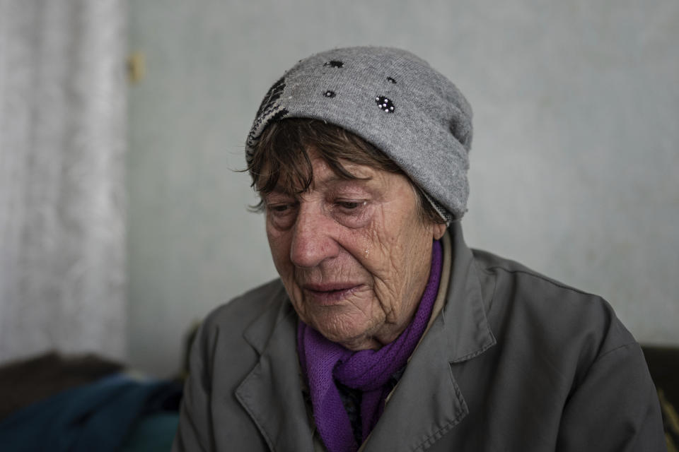 Ludmila Shabelnyk cries while showing photographs of her son Ivan Shabelnyk in the recently liberated village of Kapitolivka near Izium, Ukraine, Sunday, Sept. 25, 2022. His hands were shot, his ribs broken, his face unrecognizable. They identified him by the jacket he wore, from the local grain factory where he worked. (AP Photo/Evgeniy Maloletka)