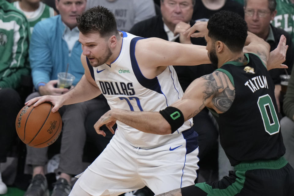 Dallas Mavericks guard Luka Doncic tries to drive past Boston Celtics forward Jayson Tatum (0) during the first half of Game 2 of the NBA Finals basketball series, Sunday, June 9, 2024, in Boston. (AP Photo/Steven Senne)