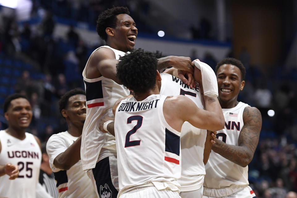 Connecticut's Christian Vital, top left, Connecticut's James Bouknight, front center, and Connecticut's Brendan Adams, back right, congratulate Connecticut's Isaiah Whaley at the end of an NCAA college basketball game against Central Florida, Wednesday, Feb. 26, 2020, in Hartford, Conn. (AP Photo/Jessica Hill)