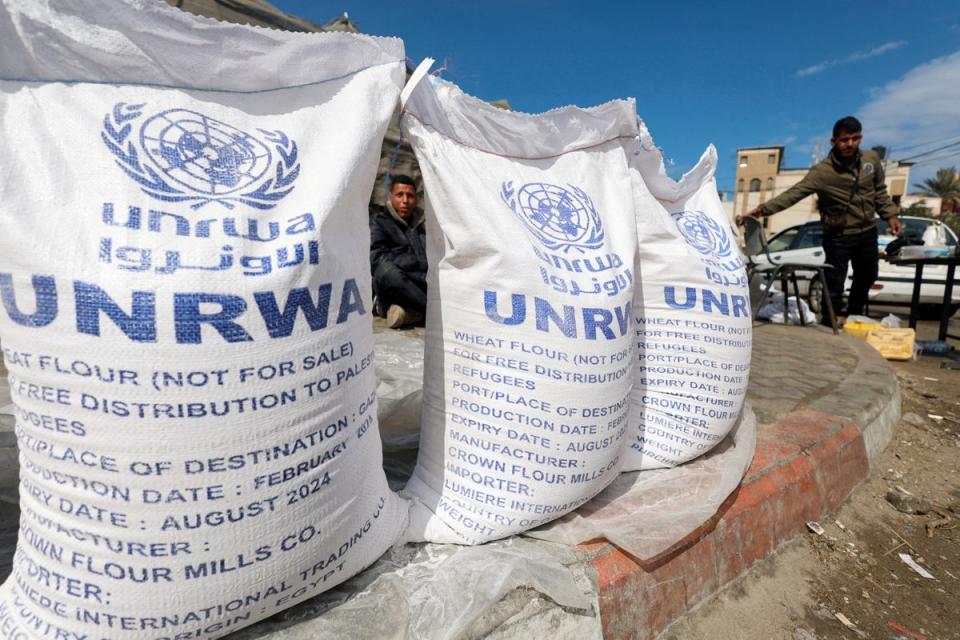 Displaced Palestinians wait to receive  UNRWA aid in Rafah (REUTERS)