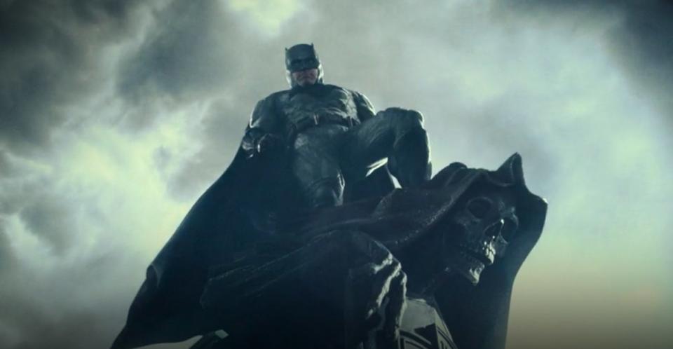 Batman standing on top of a skeleton statue in "Zack Snyder's Justice League"