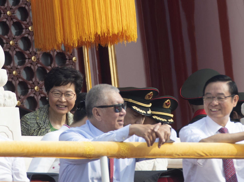 Hong Kong leader Carrie Lam, left, attends the the celebration to commemorate the 70th anniversary of the founding of Communist China in Beijing, Tuesday, Oct. 1, 2019. (AP Photo/Ng Han Guan)