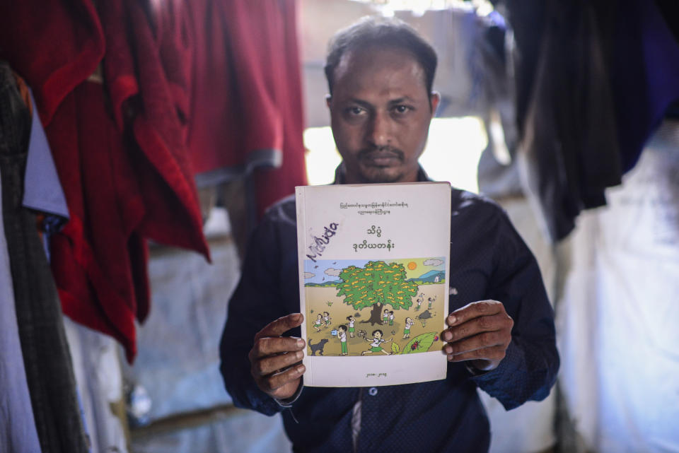 Rohingya refugee Bashir shows his 8-year-old niece Majida Bibi’s schoolbook at his shelter in the Kutupalong refugee camp in the Cox's Bazar district of Bangladesh, on March 6, 2023. (AP Photo/Mahmud Hossain Opu)