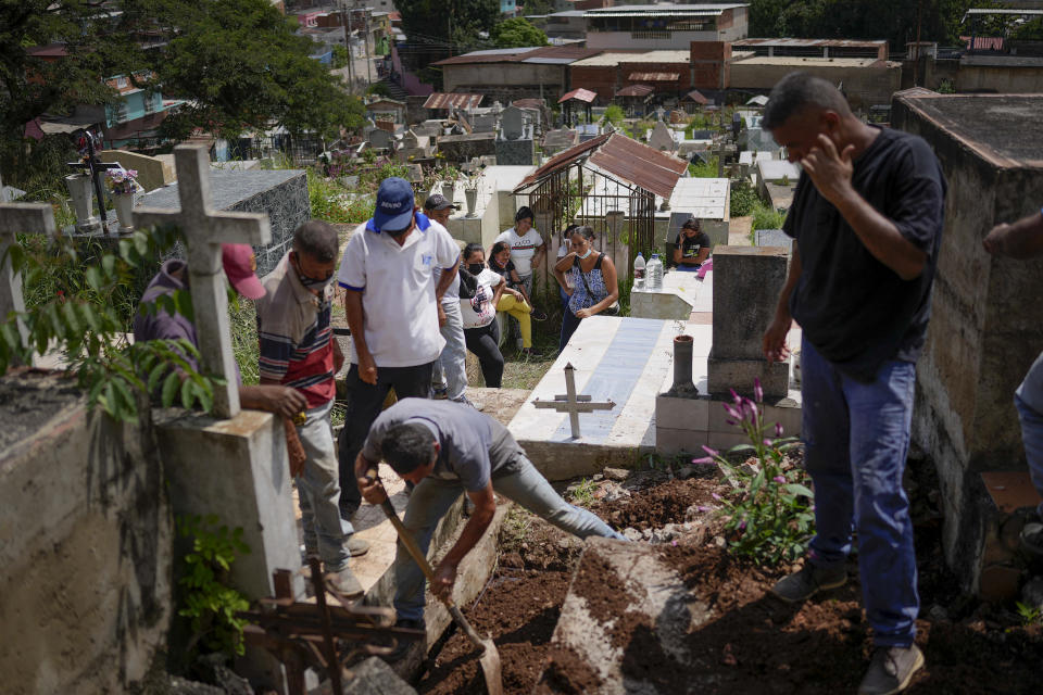 Relatives mourn during the burial of Elpidia Rodriguez in Las Tejerias, Venezuela, Wednesday, Oct. 12, 2022. Rodriguez was among dozens killed when a landslide fueled by flooding swept Las Tejerias on the night of Oct. 9. (AP Photo/Matias Delacroix)