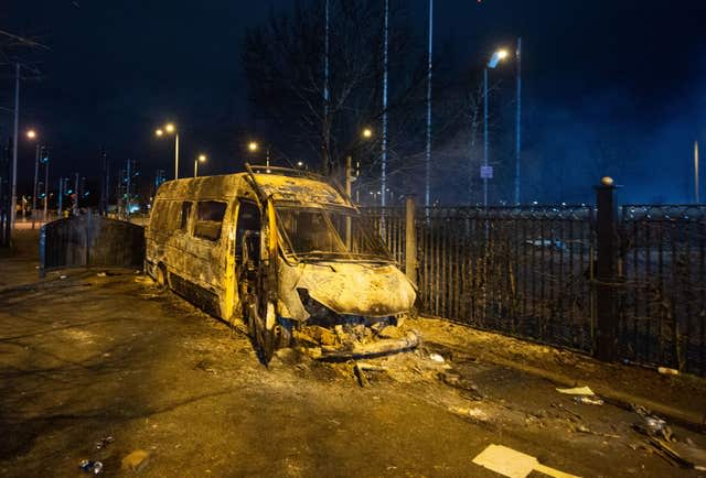 A burnt out police van after a demonstration outside the Suites Hotel in Knowsley, Merseyside.