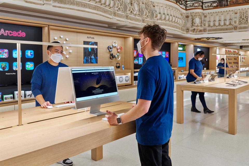 Retail workers on the sales floor at the Tower Theater Apple Store