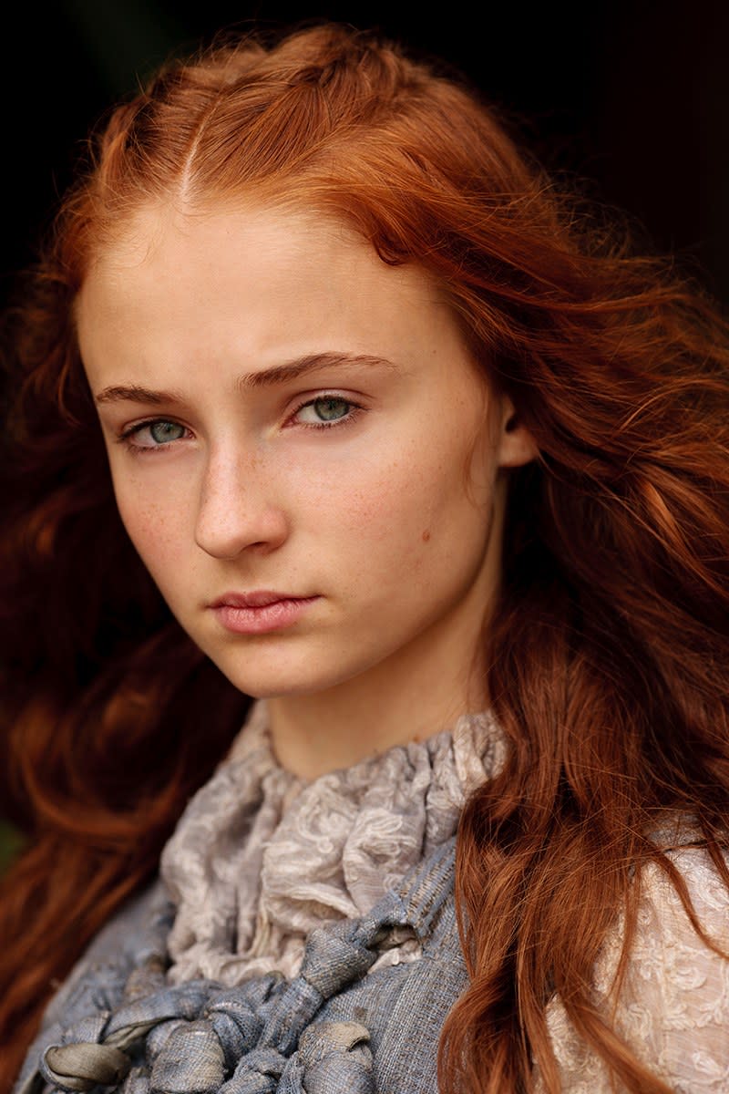 This full-on glamour shot of <strong>Sophie Turner</strong> as Sansa Stark in Season 1 is the perfect place to start to show the juxtaposition of her journey. Take a look at the brightness of her hair, the looseness of the waves, the <a href="https://www.allure.com/story/sophie-turner-interview-favorite-beauty-products-sansa-survivor?mbid=synd_yahoo_rss" rel="nofollow noopener" target="_blank" data-ylk="slk:rosiness in her cheeks;elm:context_link;itc:0;sec:content-canvas" class="link ">rosiness in her cheeks</a> and the scattering of freckles across her nose, and even the light, gauzy quality of her clothing. This is a child of summer, whose biggest worry is her annoying little sister.