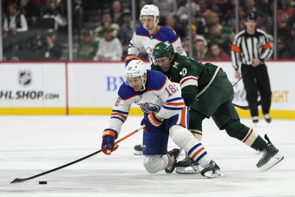 Edmonton Oilers left wing Zach Hyman (18) and Minnesota Wild center Vinni Lettieri vie for the puck during the second period of an NHL hockey game Tuesday, Oct. 24, 2023, in St. Paul, Minn. (AP Photo/Abbie Parr)