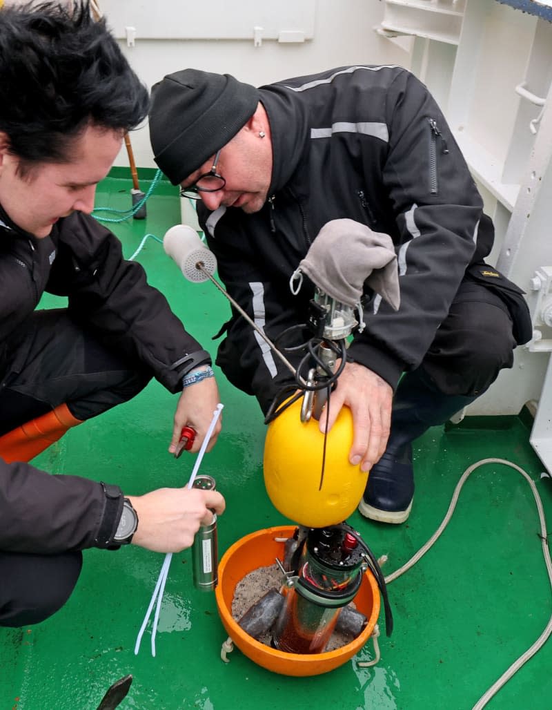 On board the fisheries research vessel Solea on the Baltic Sea, Thomas Noack (l-r), biologist and fisheries technician at the Thünen Institute of Baltic Sea Fisheries, and Kai Handke, fisherman from Korswandt (Usedom), prepare a sensor camera with bait for use. Bernd Wüstneck/dpa