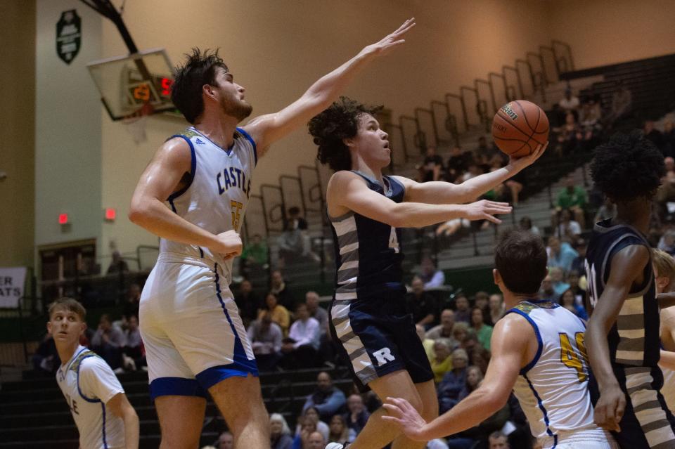 Reitz’s Will Kirkland (4) leaps for a basket as Castle's Dylan Watson (55) attempts to block during their game at North High School in Evansville, Ind., on Tuesday, Feb. 28, 2023.