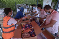 Non-governmental organization Resala Nour Ala Nour workers prepare cartons filled with food to distribute to people who have been greatly affected by the coronavirus outbreak, in Cairo, Egypt, Thursday, April 9, 2020. (AP Photo/Nariman El-Mofty)