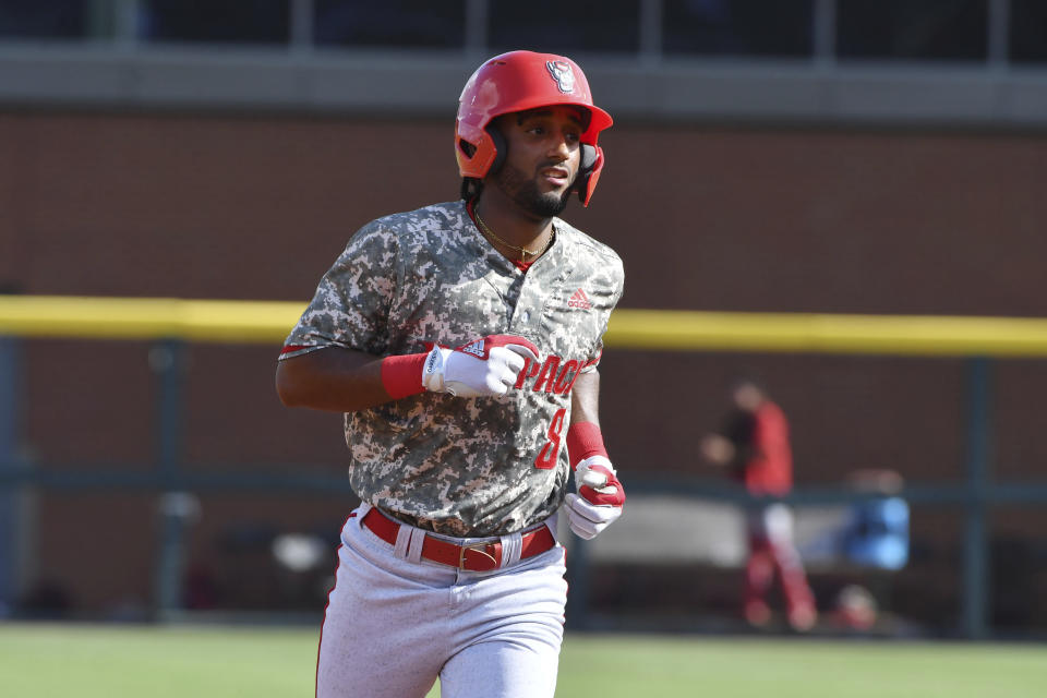 North Carolina State baserunner Jose Torres (8) rounds the basses after hitting a home run against Arkansas in the second inning of an NCAA college baseball super regional game Friday, June 11, 2021, in Fayetteville, Ark. (AP Photo/Michael Woods)