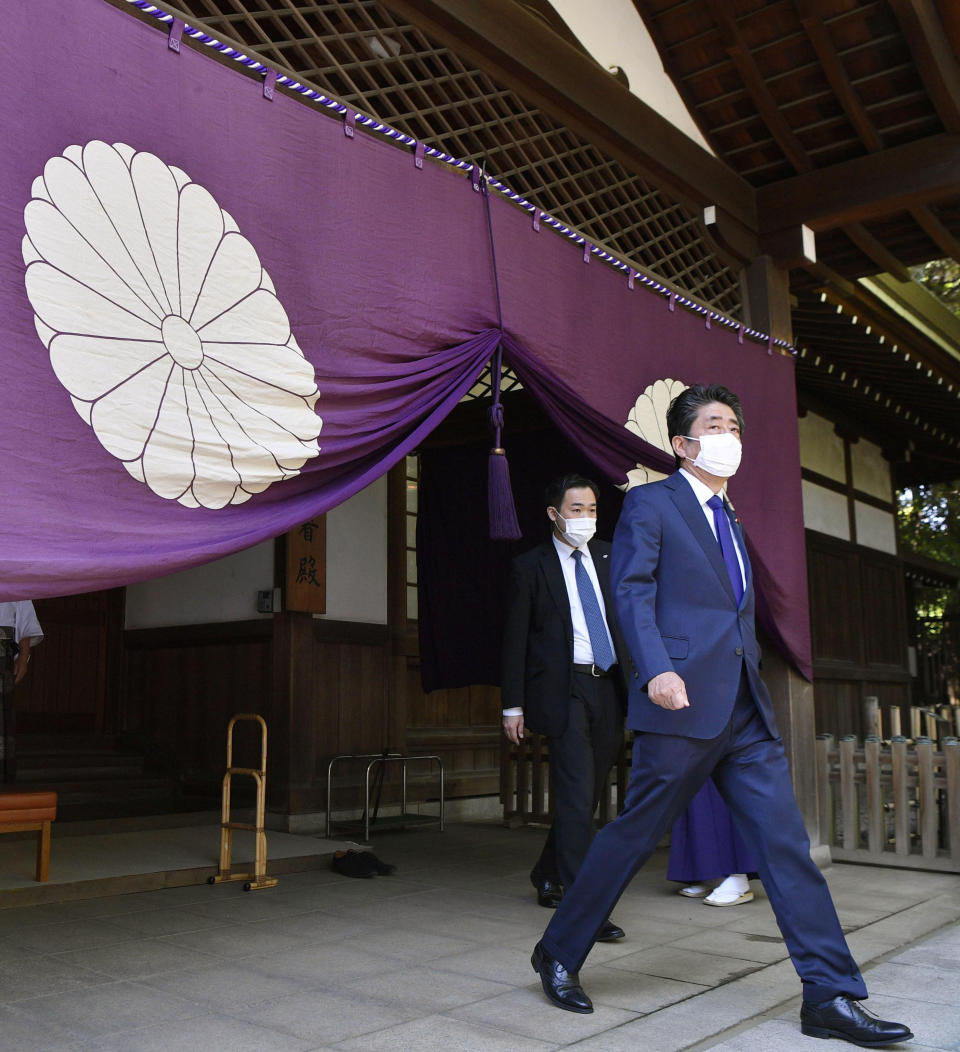 Former Japanese Prime Minister Shinzo Abe, right, leaves after praying at Yasukuni Shrine in Tokyo Wednesday, April 21, 2021, the first day of the annual Spring Rites, the shrine’s biannual festival honoring the war dead, including Japanese war criminals. (Tsuyoshi Ueda/Kyodo News via AP)