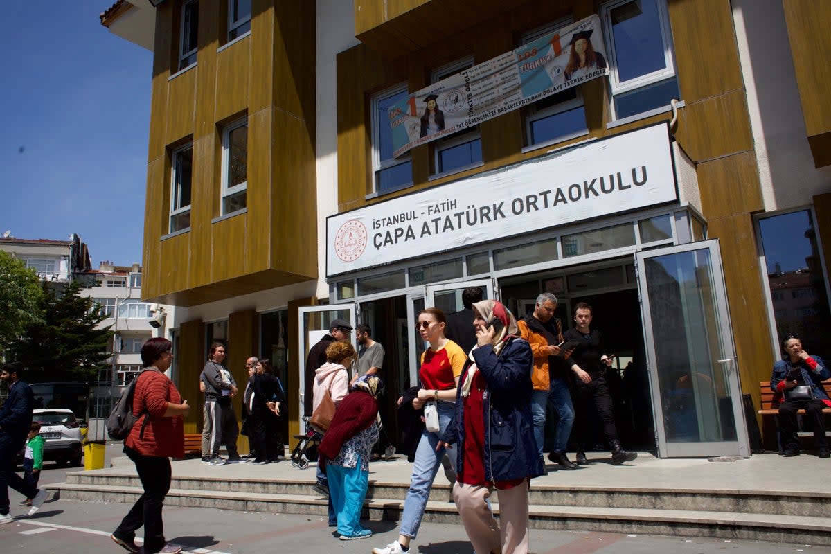 Voters emerge from a balloting station in the Istanbul district of Fatih (Yusuf Sayman/ The Independent)