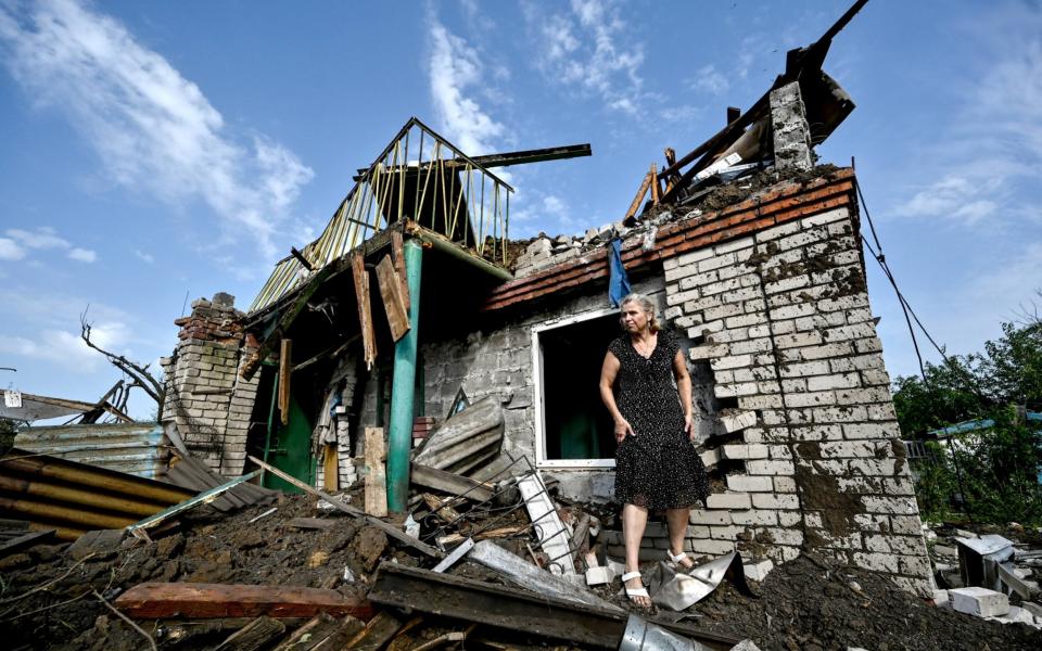 A woman by a destroyed house following Russian missile attacks on Zaporizhzhia - SGSAN/MEGA