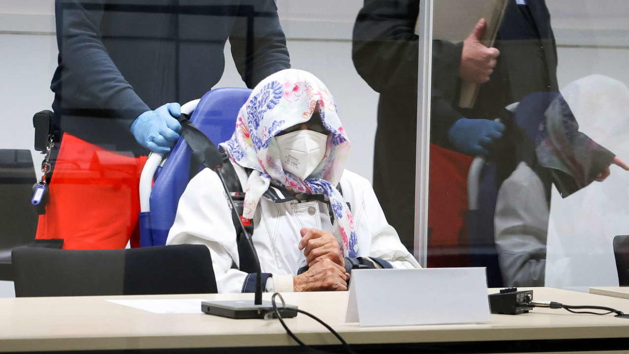 Irmgard Furchner, a 96-year-old former secretary to the SS commander of the Stutthof concentration camp, arrives in a wheelchair as her lawyers Niklas Weber and Wolf Molkentin look on at the beginning of her trial in a courtroom, in Itzehoe, Germany, October 19, 2021. Christian Charisius/Pool via REUTERS