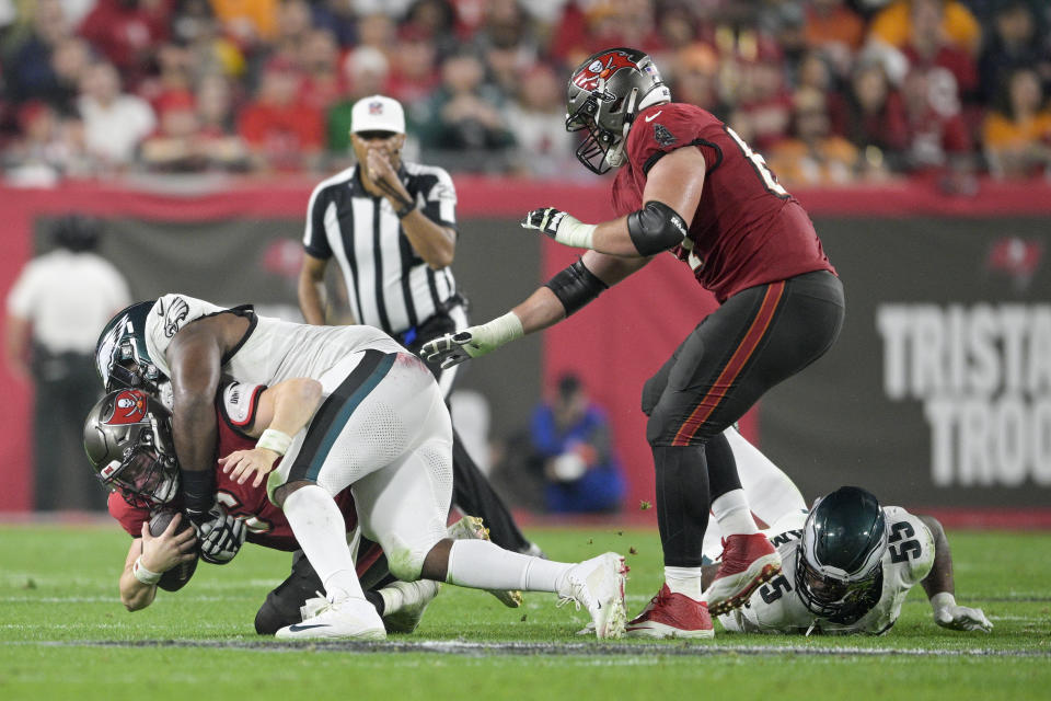 Tampa Bay Buccaneers quarterback Baker Mayfield, bottom left, is sacked by Philadelphia Eagles defensive tackle Fletcher Cox during the first half of an NFL wild-card playoff football game, Monday, Jan. 15, 2024, in Tampa, Fla. (AP Photo/Phelan M. Ebenhack)