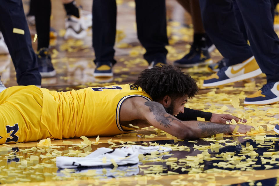 Michigan forward Isaiah Livers makes confetti angels on the court after the team's win over Michigan State in an NCAA college basketball game, Thursday, March 4, 2021, in Ann Arbor, Mich. Michigan won the Big Ten title. (AP Photo/Carlos Osorio)