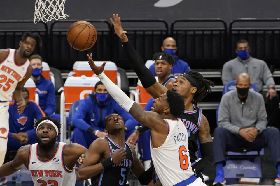 New York Knicks guard Elfrid Payton, second from right, goes to the basket against Sacramento Kings center Richaun Holmes, right, during the first quarter of an NBA basketball game in Sacramento, Calif., Friday, Jan. 22, 2021. (AP Photo/Rich Pedroncelli)