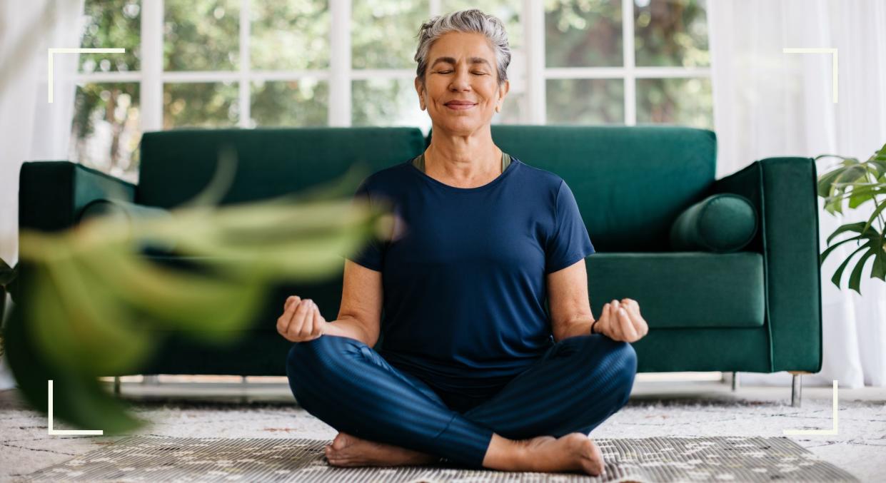  Woman meditating at home, representing one of the New Year's resolution ideas to try in 2024. 