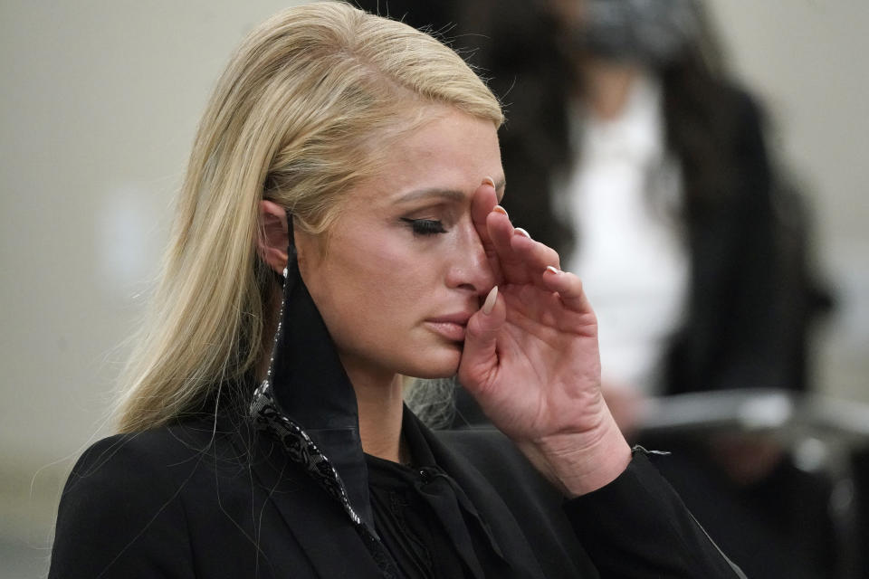 Paris Hilton se seca las lágrimas tras hablar en una audiencia de comisión del Senado en el Capitolio de Utah el 8 de febrero de 2021 en Salt Lake City. Hilton testificó sobre los abusos que sufrió en un internado de Utah en la década de 1990 ante legisladores que promueven una ley para regular la industria. (Foto AP/Rick Bowmer)