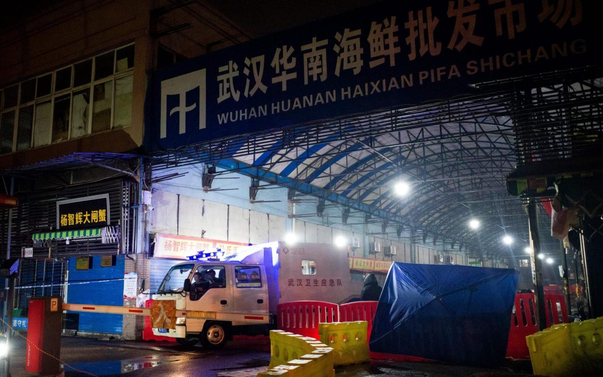 Members of the Wuhan Hygiene Emergency Response Team leaving the closed Huanan Seafood Wholesale Market in mid-January 2020 - NOEL CELIS/AFP via Getty Images