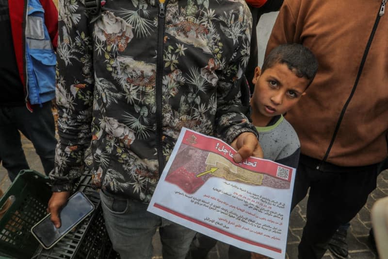 Palestinians holds a leaflet dropped by the military aircraft of the Israeli army on the east of the city of Rafah, ordering them to evacuate and move towards the west of the city and the city of Khan Yunis. The leaflet says that all residents of eastern Rafah must evacuate immediately. The aforementioned area is area of conflict and fighting. Abed Rahim Khatib/dpa