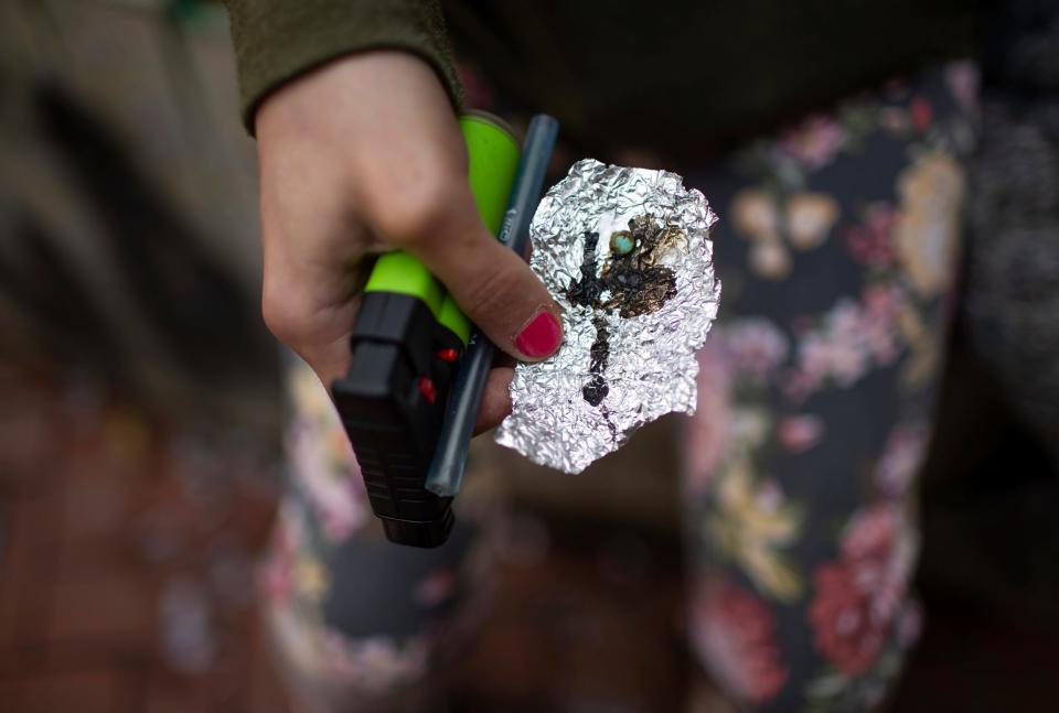 A person holds drug paraphernalia near the Washington Center building in downtown Portland. Public drug use in cities such as Portland and a surge in fentanyl overdose deaths have created a backlash against the first-in-the-nation ballot measure decriminalizing illicit drugs.