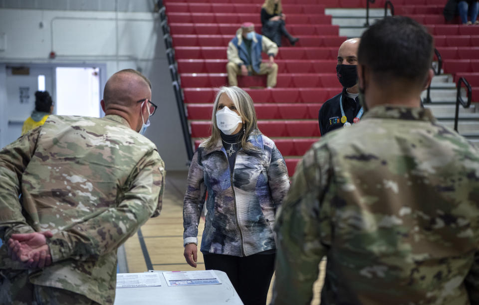 New Mexico Governor Michelle Lujan Grisham talks with National Guardsmen after receiving her Pfizer COVID-19 vaccine during a vaccination event held in the gym at Desert Sage Academy in Santa Fe, N.M. Friday March 26, 2021. (Eddie Moore/The Albuquerque Journal via AP, Pool)