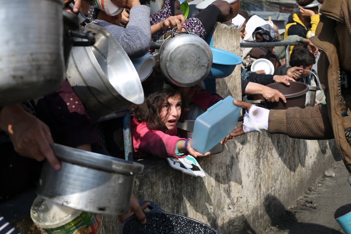 Palestinians line up for free food during the ongoing Israeli air and ground offensive on the Gaza Strip in Rafah (Copyright 2024 The Associated Press. All rights reserved.)